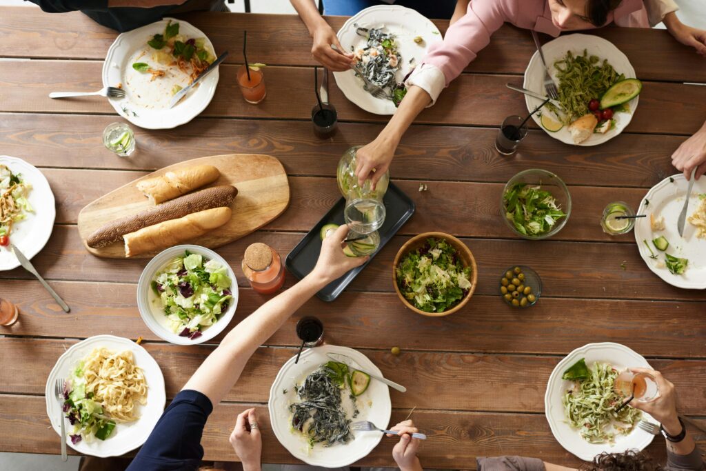 pexels photo 3184192 3184192 An overhead shot of a dining table featuring various pasta dishes and salads shared by a group.