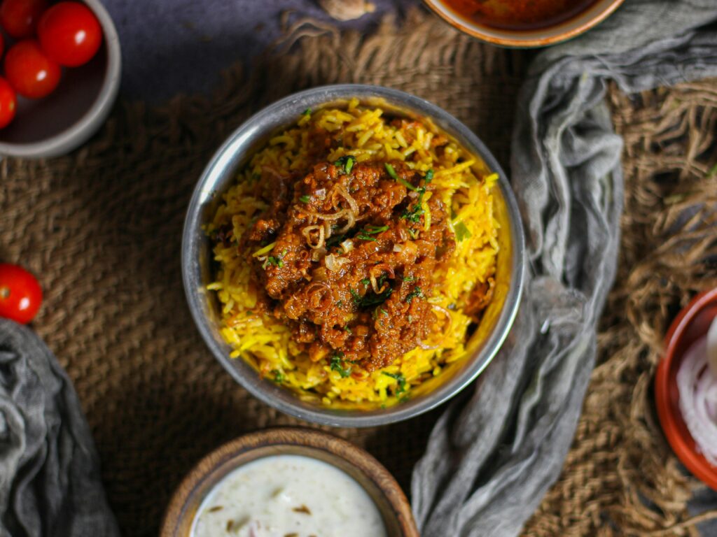 pexels photo 9609855 9609855 Top view of spicy Indian biryani served with raita, a perfect blend of flavors.